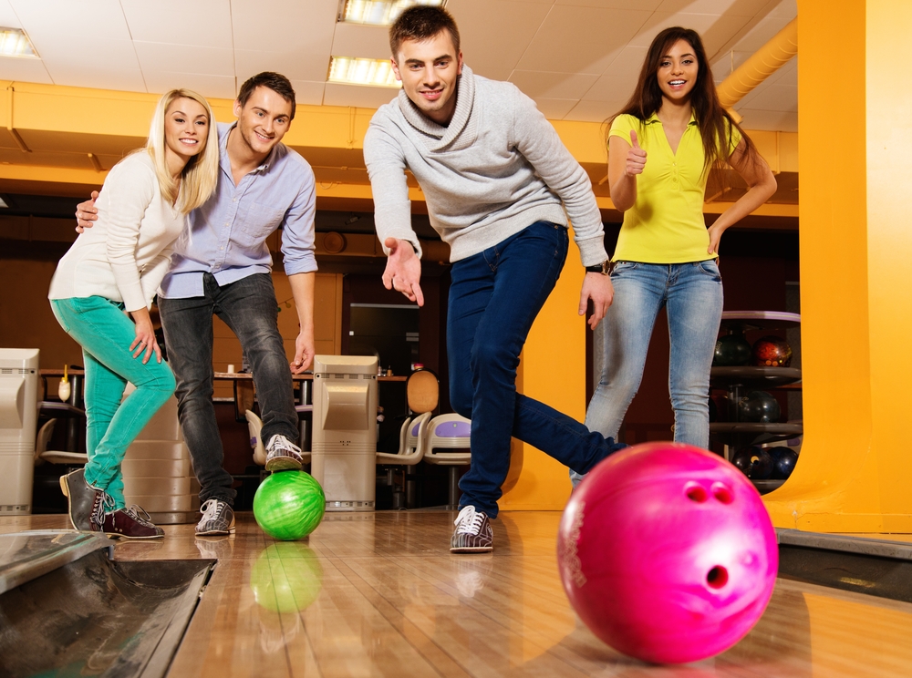 The male bowler in the gray sweater used two plastic bowling balls in the tenth frame for a spare.