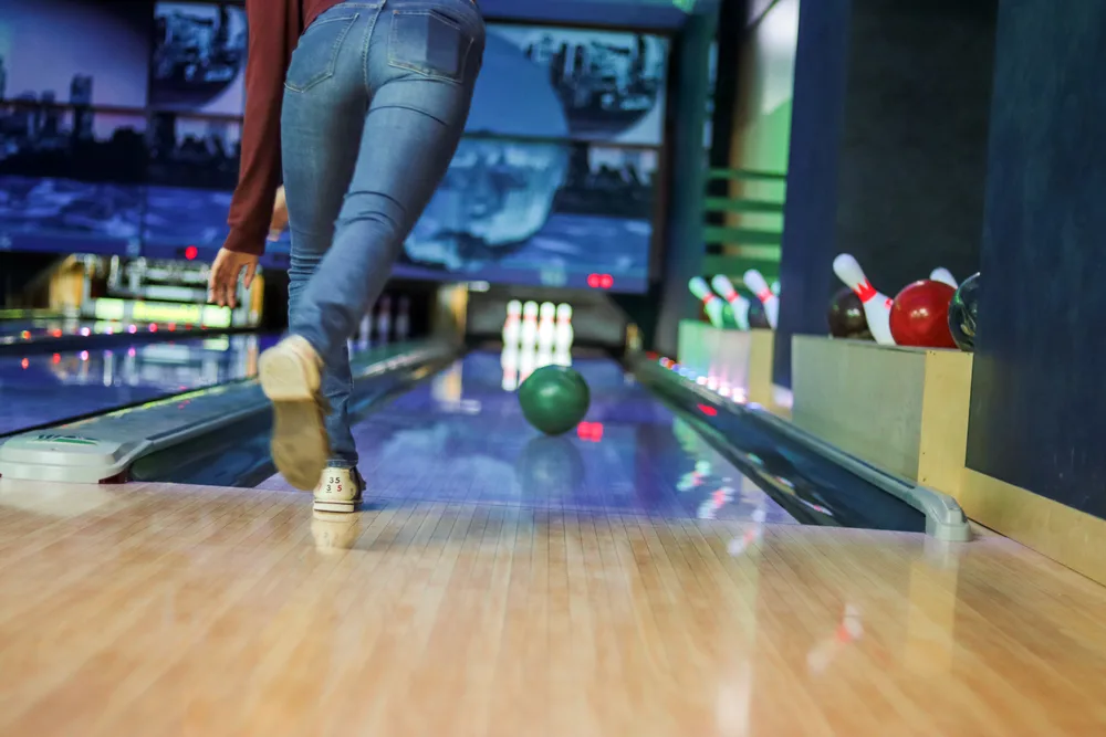 The bowler rolled the green plastic ball (house ball) down the lane.