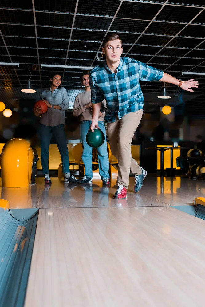 The bowlers in the background made a positive comment to the bowler at the line.