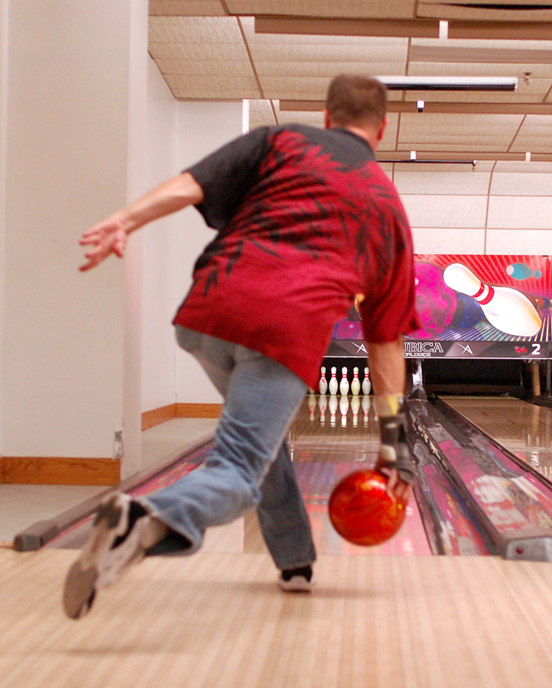 Bowler in red shirt rolling red bowl has practiced so they'll have the perfect bowling game