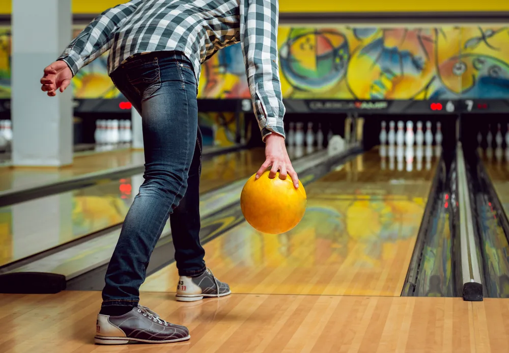 Young man at the bowling alley with two bowling balls