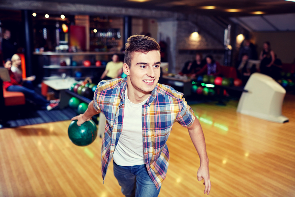 Male bowler in plaid shirt with green ball understanding the montreal oil attern