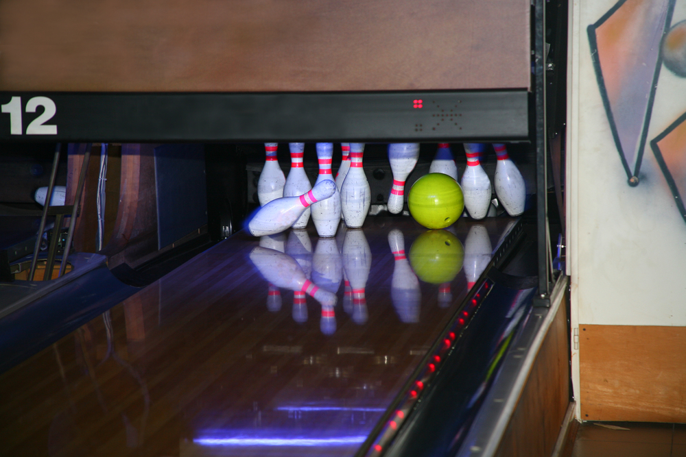 Yellow bowling ball and bowling pins on the lane at a bowling center missed the pocket