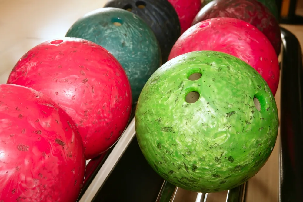The red house ball on a ball return rack is used a spare ball