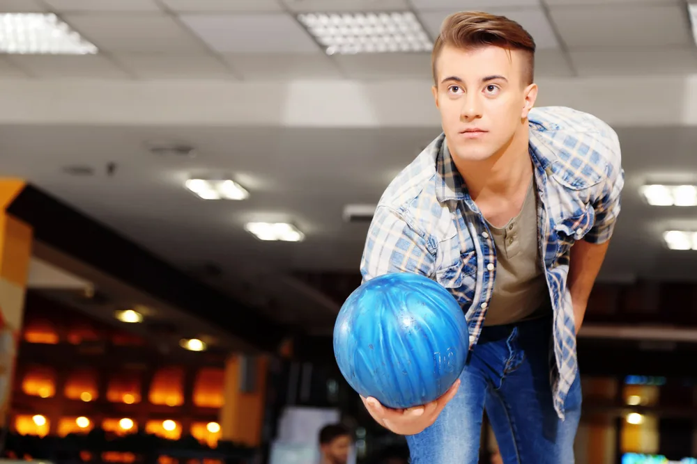 Bowler in white/blue plaid shirt with blue bowling ball and because he misunderstood the oil pattern bowled a low game