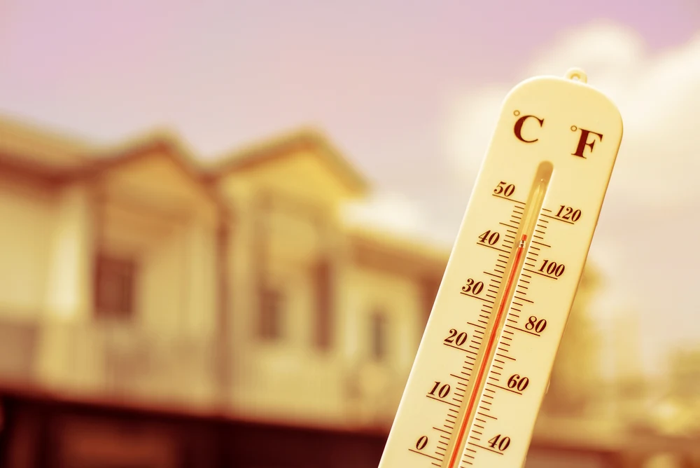 Outdoor thermostat with temperature over 100 degrees fahrenheit while bowling ball sits in the garage