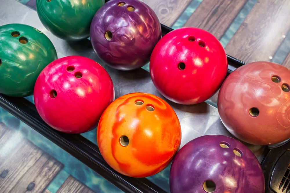 Variety of coloful bowling balls but the orange is their own ball
