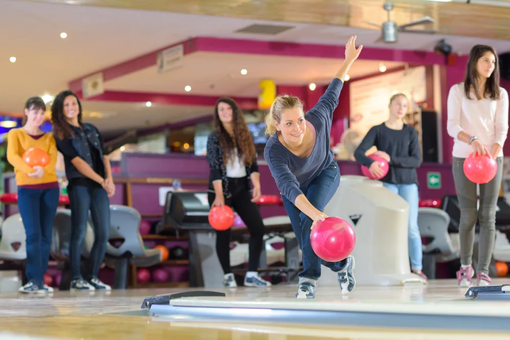 The woman bowler in the blue shirt rolling the pink ball had two gutter balls and realized chichen itza pattern was not light and easy