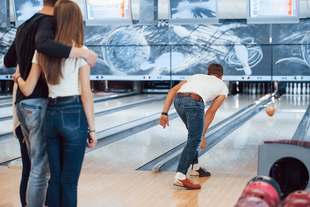 Bowler rolled orange bowling ball down the lane as bowling exercise for his back.