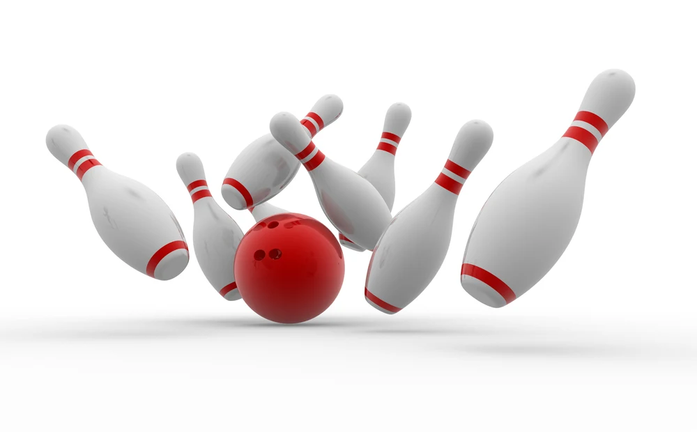 Bowling ball crashing into the pins that are all the standard size