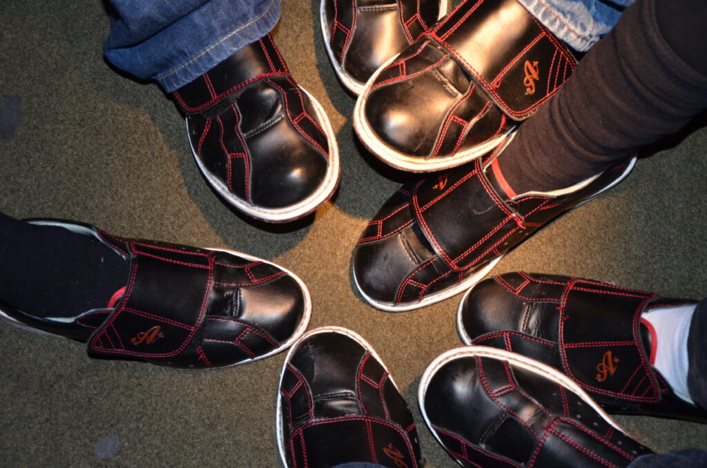 Image of family's feet that decided to wear bowling shoes