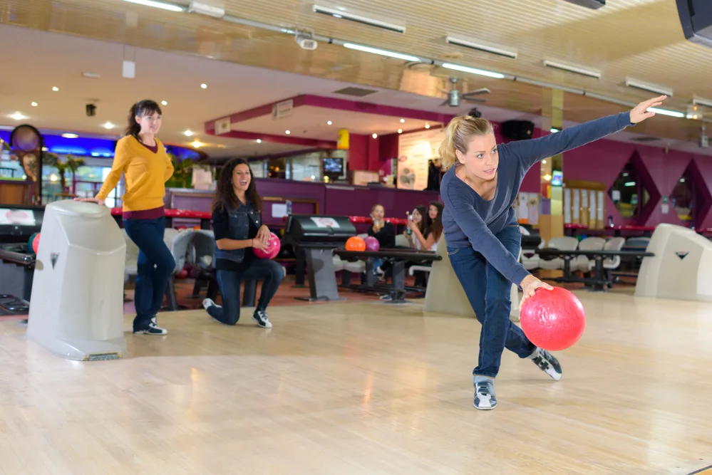 Woman bowler at bowling alley rolled pink bowling ball down the middle to create a small hold area to the pocket