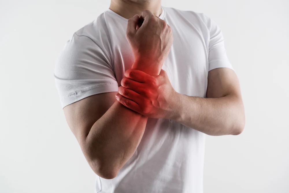 Bowler in white t-shirt feel muscle strains in their arm and wrist