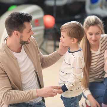 Child and parents bonding over bowling