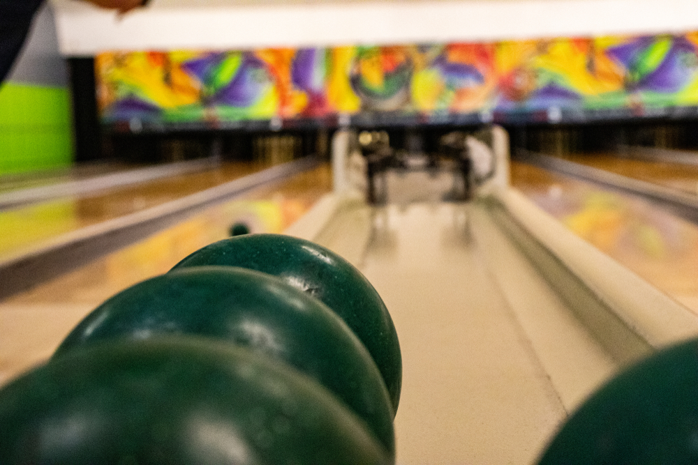 Green candlepin bowling balls sitting on the ball return bowler wonders how much does a candlepin bowling ball weigh