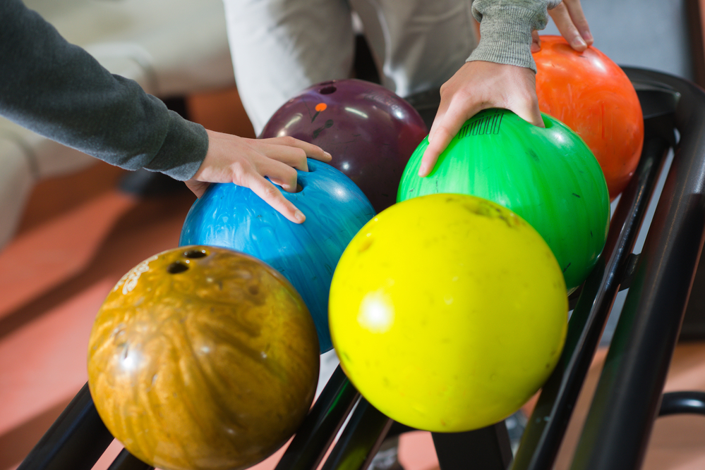 Three friends choosing their bowling balls