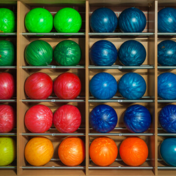 Colorful bowling balls on rack in pro shop