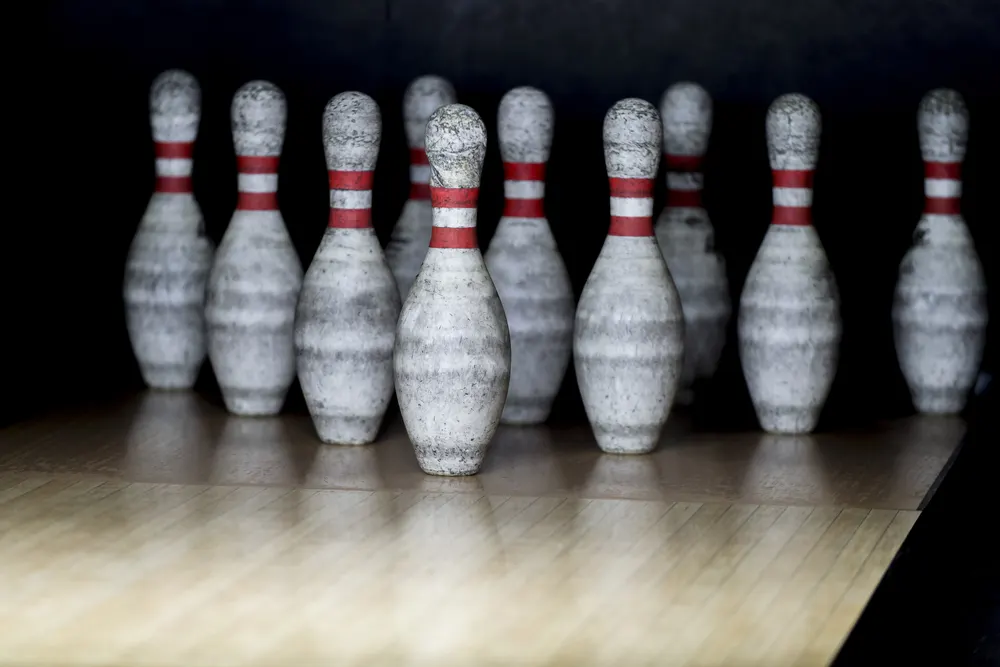 Solid pins at the bowling alley with an automatic pin setter above it.