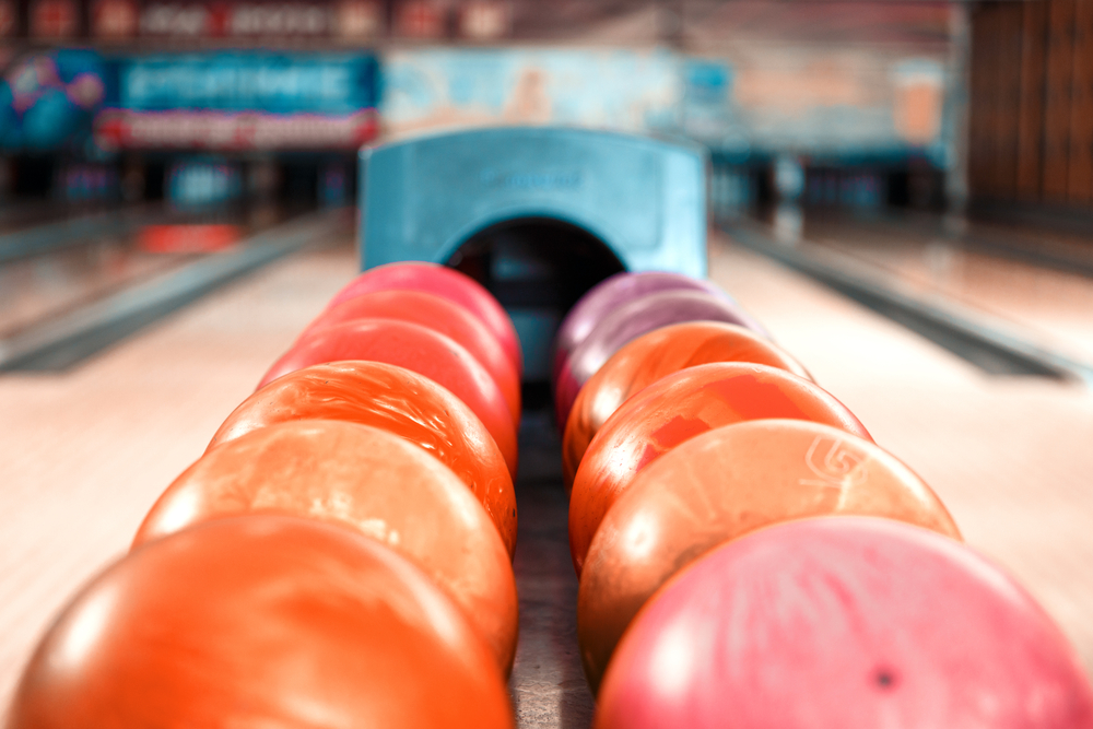 Multiple colorful bowling balls on ball return