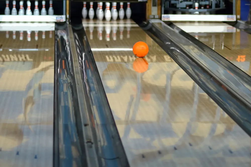 Rolling orange ball on a lane that has a beautiful shine