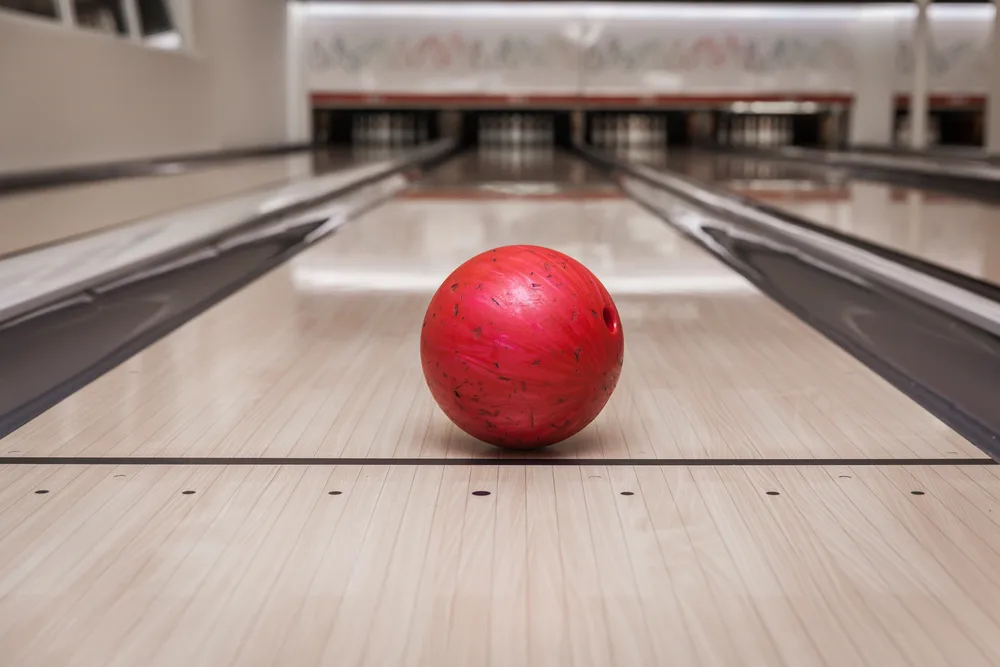 Red bowling ball on lane with glazed appearance that was wiped with a clean soft cloth