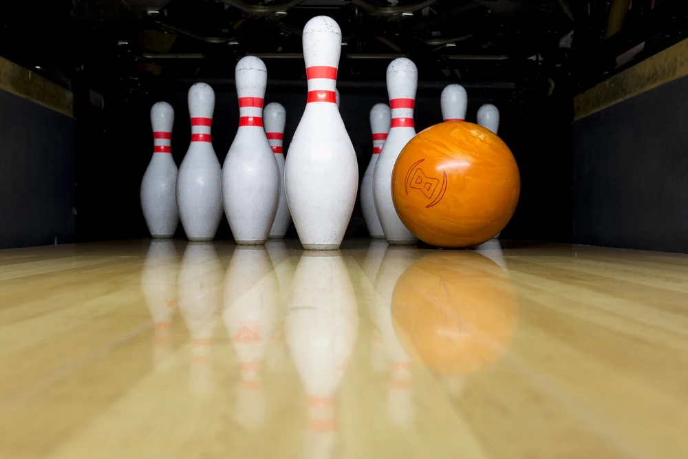 Orange performance bowling balls on the bowling lane.