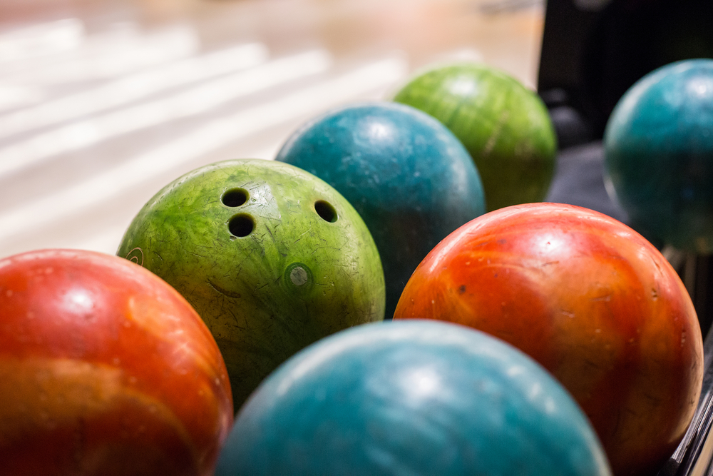 The green bowling ball on the ball return is a house ball.