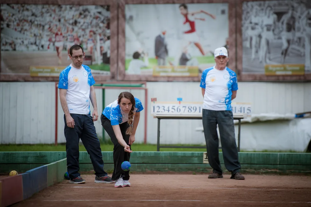 Team bowlers follow game rules and etiquette as they deliver the bowl down the court