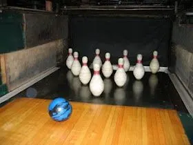 Shows duck pin bowling ball and pins at the end of the lane.
