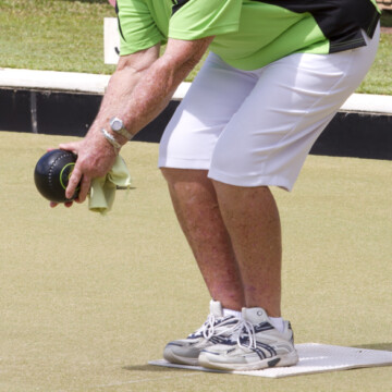 Playing lawn bowling ball on green