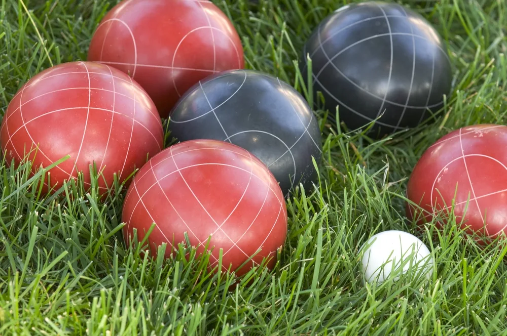 Closeup of bocce balls at the half court line on green grass