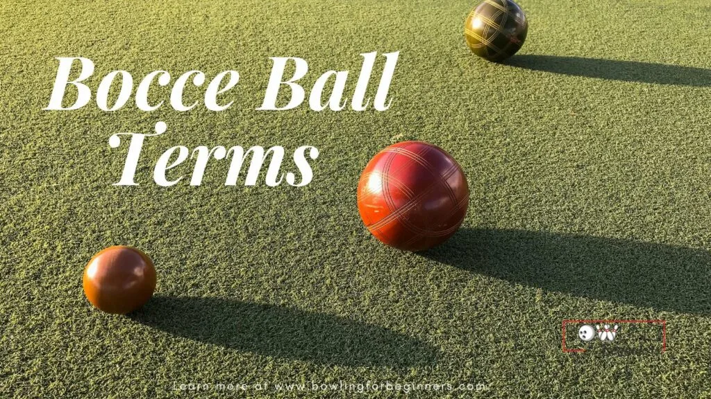 Bocce balls on green grass, where the red bocce ball is closest to the smaller ball or jack