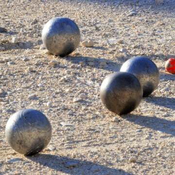 Petanque ball in gravel and red jack