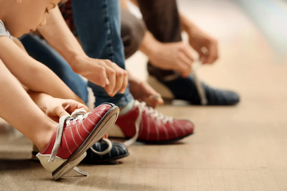 Family putting on bowling shoes that are tri colored