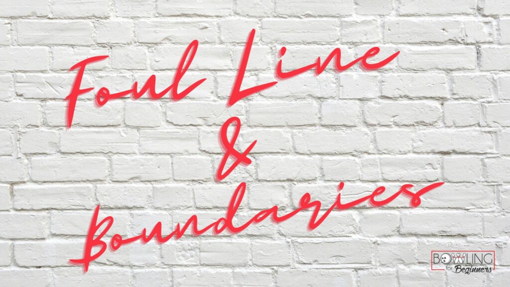 White brick wall with red font that read foul line and boundaries