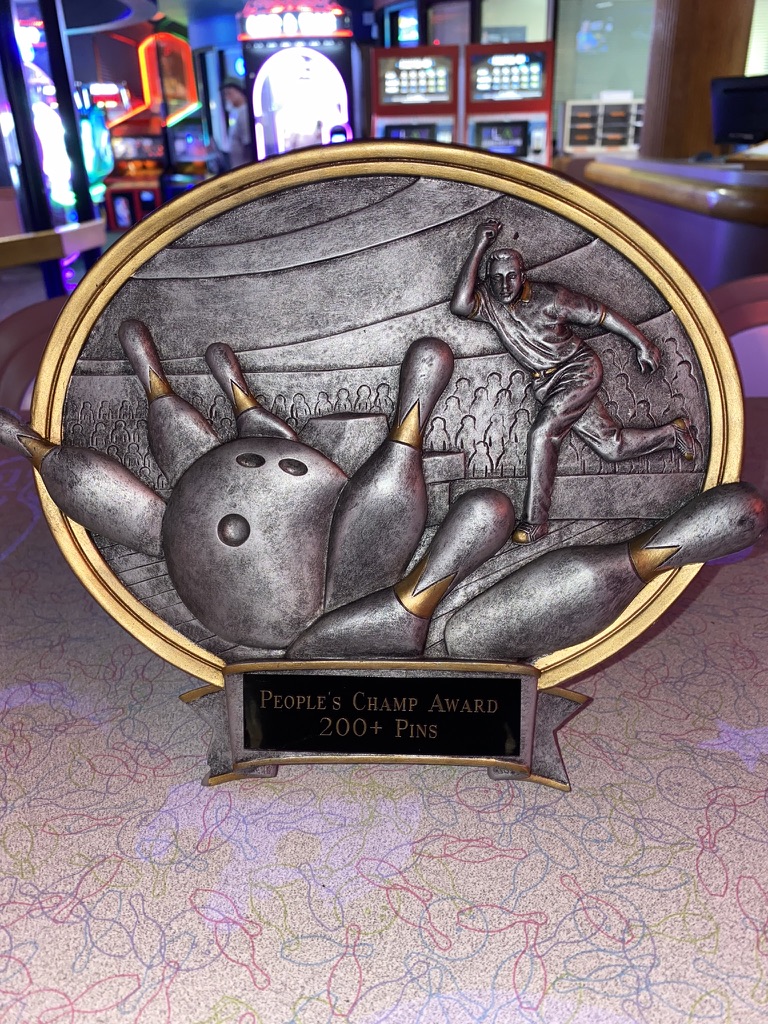Silver and gold bowling award with embossed bowling balls and pins with a bowler is apart of the list of bowling awards ideas