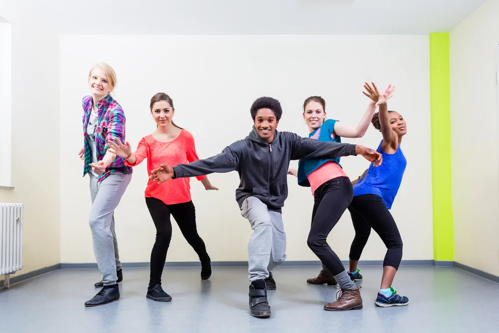 Group of young people having dance class in gym