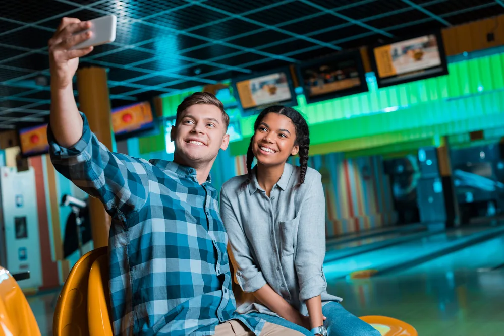 Male and female taking selfies after a successful bowling session
